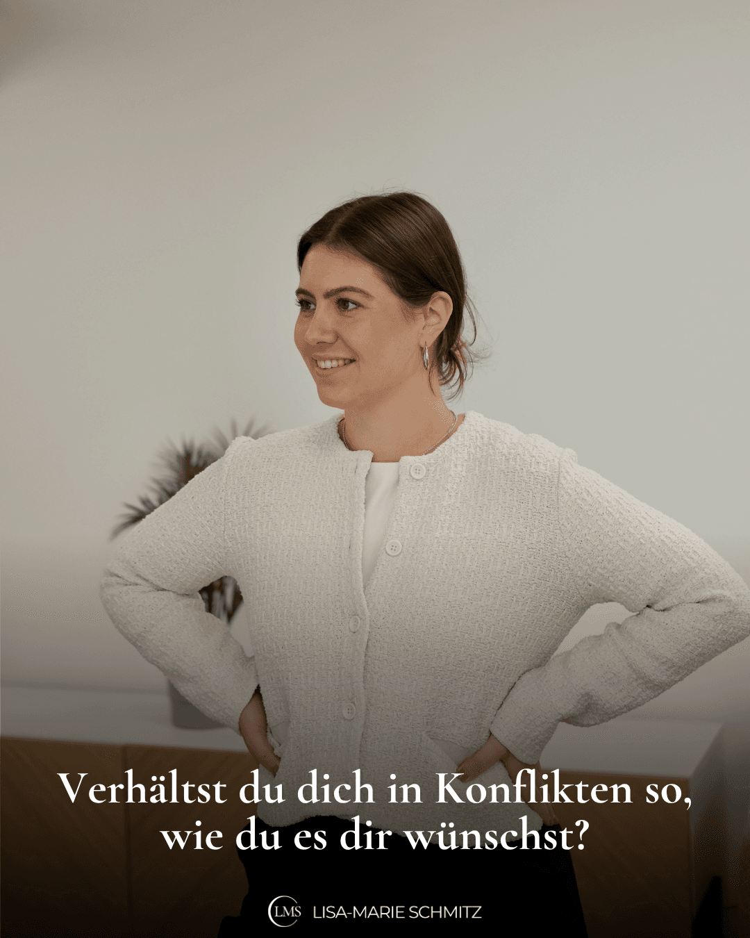 Lisa-Marie steht in einem weißen Oberteil im Raum, hat die Arme in die Hüften gestemmt und schaut leicht lächelnd in den Raum, auf dem Bild steht die Frage: Verhälst du dich in Konflikten so, wie du es dir wünschst?